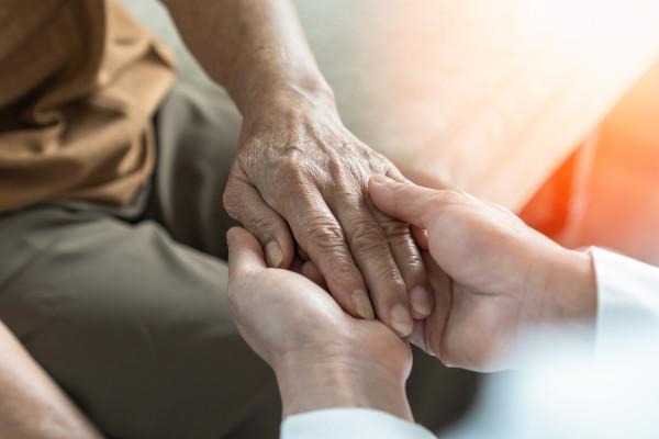 an elderly persons hand being held